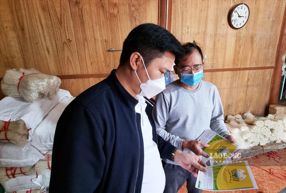 Anh Nguyễn Văn Thuật (bên phải) giới thiệu về bộ nhãn mác, thương hiệu của các sản phẩm bún, phở khô của HTX.
