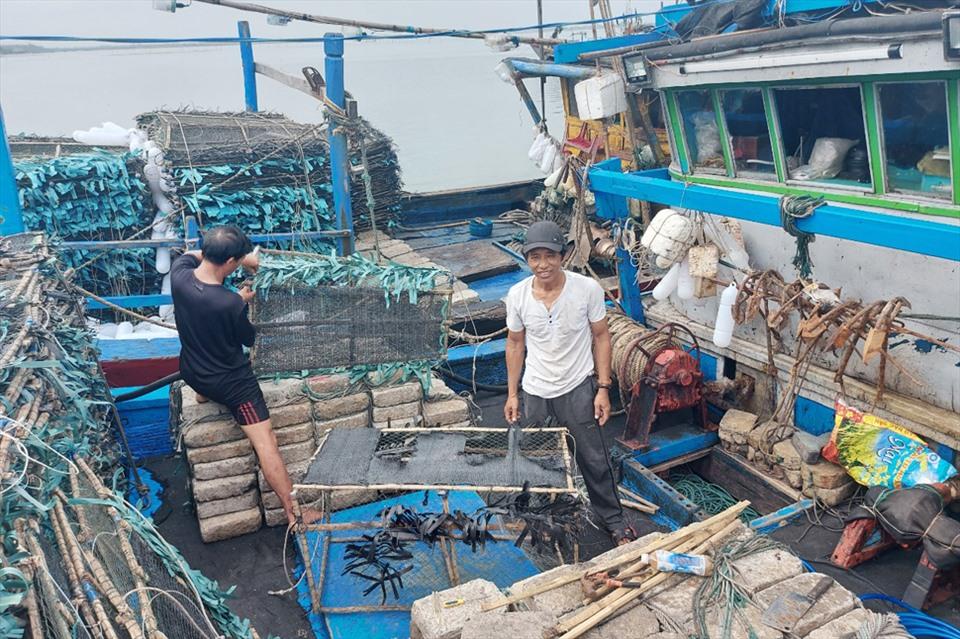 Tàu của ông Nguyễn Cư (áo trắng) cũng may mắn trúng 9 tạ mực, thu về hơn 100 triệu đồng. Ảnh: Trần Tuấn.