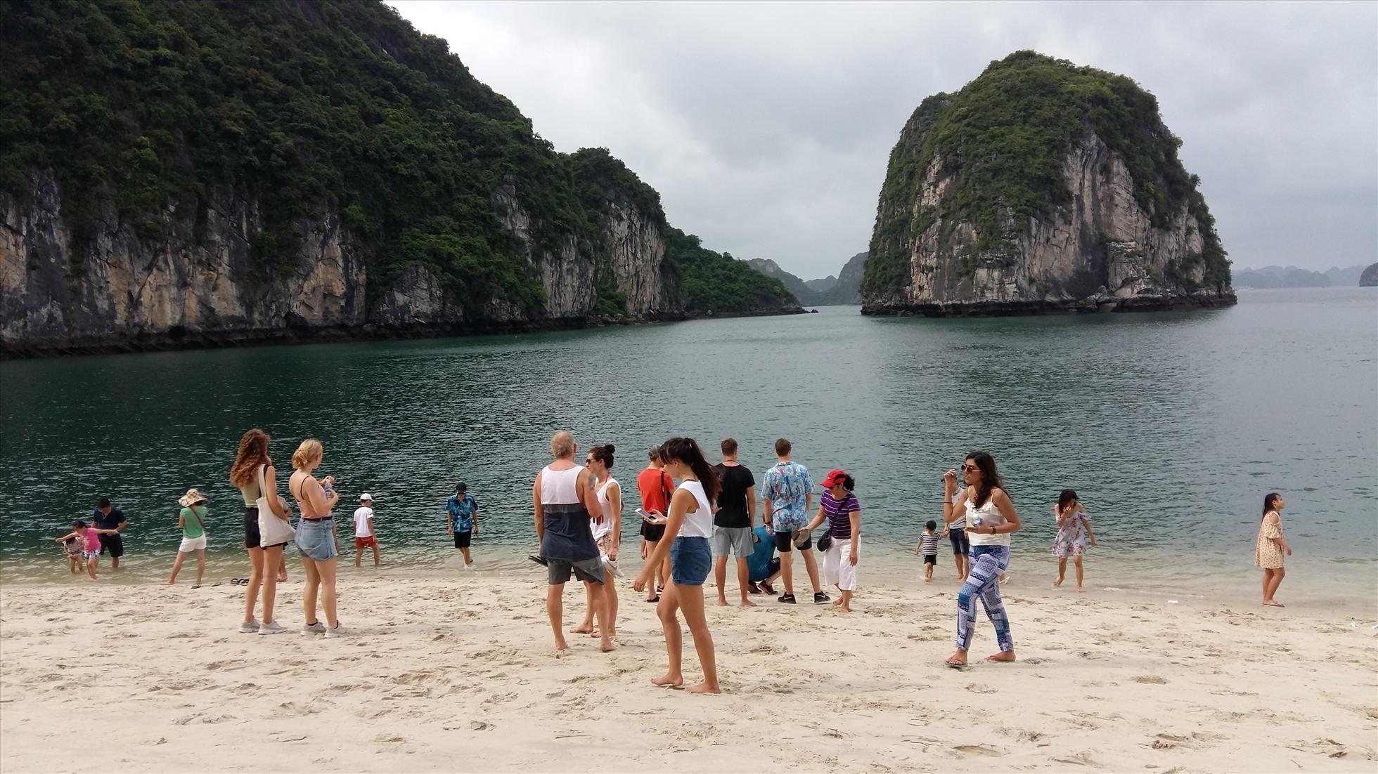 Bãi tắm đẹp, nước biển trong xanh, thời tiết nóng nực nhưng du khách cũng không được tắm nên chỉ đứng trên bãi biển ngắm cảnh. Ảnh: Nguyễn Hùng