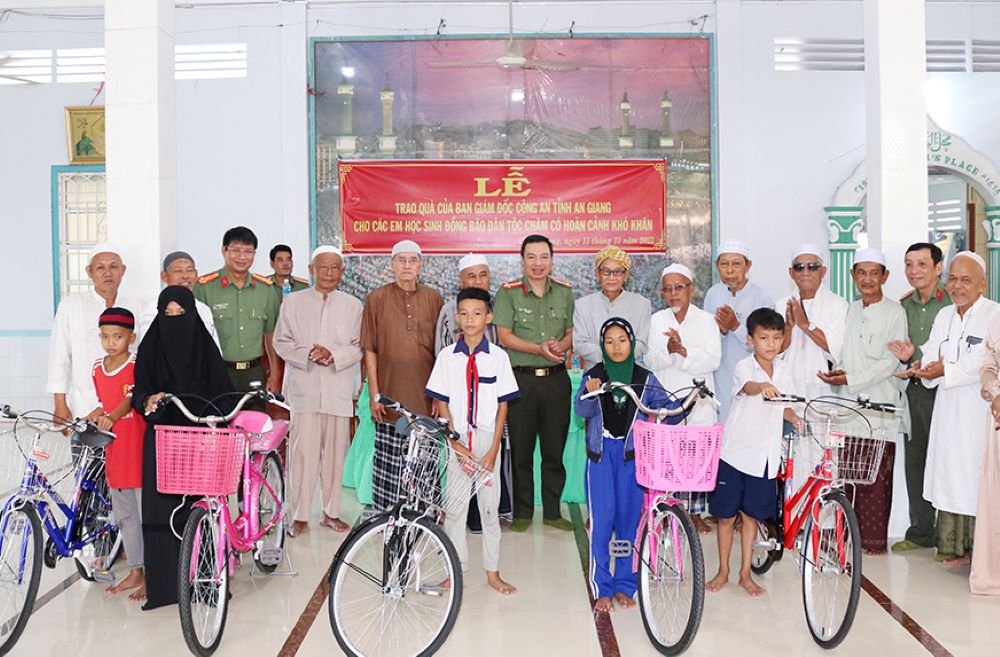 Lãnh đạo Công an tỉnh An Giang trao tặng xe đạp cho học sinh dân tộc Chăm. Ảnh: Vũ Tiến