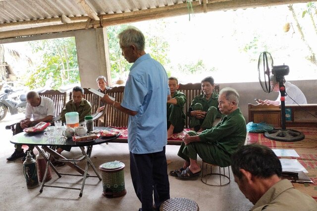 Thầy giáo Thân cùng các cụ cao niên trong xóm trao đổi, nghiên cứu về chữ viết và văn hoá dân tộc Dao Tiền. Ảnh: Minh Tùng.