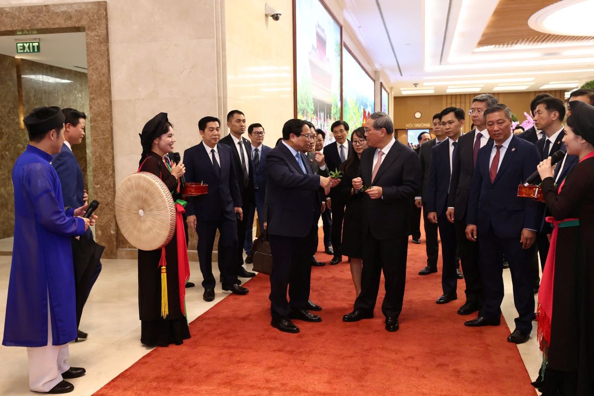 Các nghệ sĩ Quan họ Bắc Ninh giới thiệu và mời hai Thủ tướng, các đoàn viên “trầu cánh phượng“. Ảnh: Hải Nguyễn