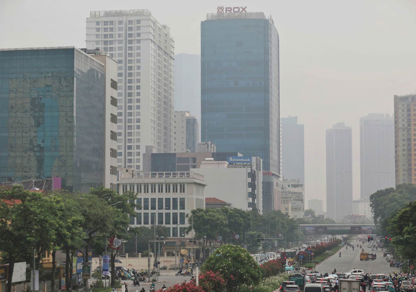 Ghi nhận đến gần trưa ngày 14.7, bầu trời Hà Nội vẫn mờ đục, các tòa nhà cao tầng mờ ảo khi nhìn từ xa.