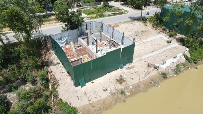 Người dân quây tôn kín khu đất thuộc hành lang kênh Vách Bắc (xã Đông Thành, tỉnh Nghệ An) đưa vật liệu xây dựng vào thi công. Ảnh: Quang Hợp