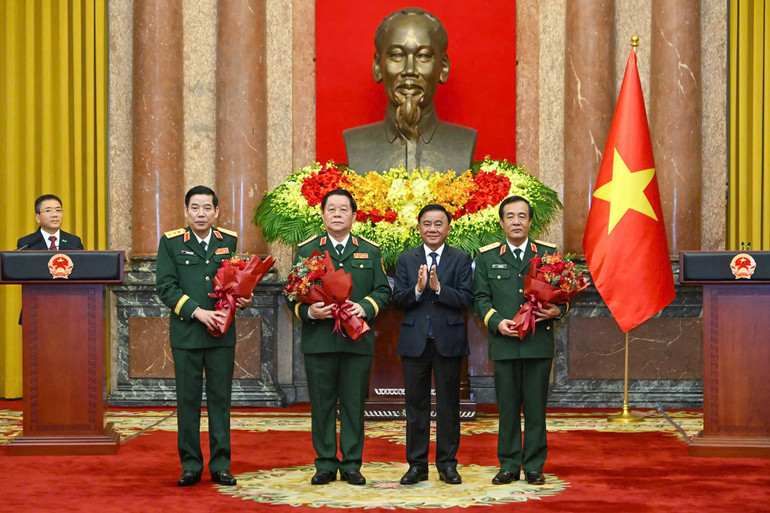 Đồng chí Trần Cẩm Tú tặng hoa chúc mừng các đồng chí được bổ nhiệm, thăng quân hàm. (Ảnh: Thủy Nguyên)