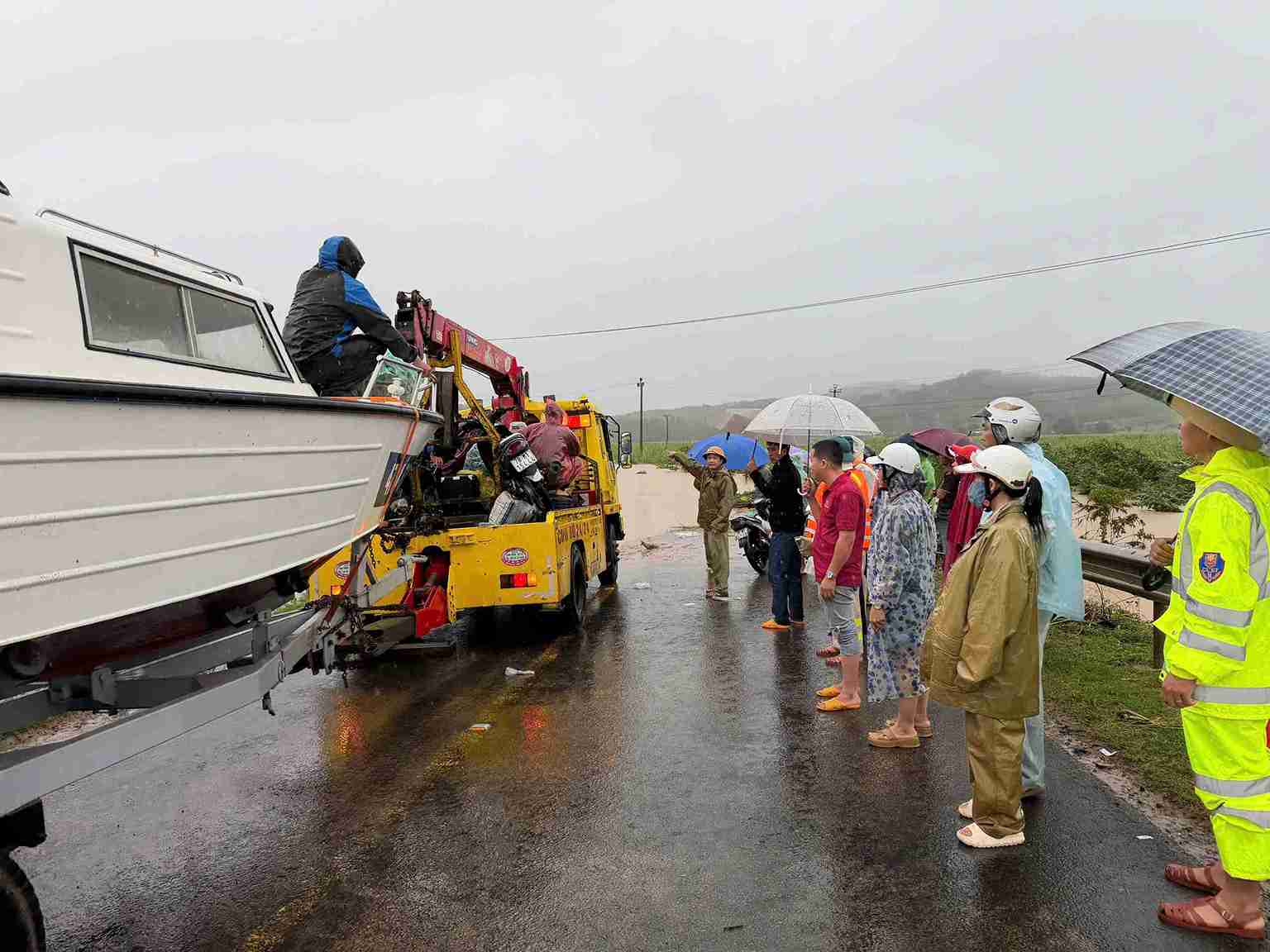 Lực lượng chức năng hỗ trợ người dân lưu thông qua vùng lũ ở khu vực phía Đông tỉnh Đắk Lắk. Ảnh: Công an cung cấp