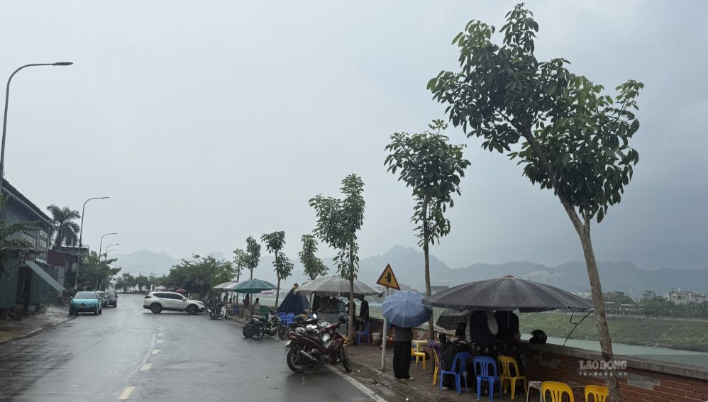 Dù thời tiết mưa nhưng nhiều người dân đến khu vực chân đập theo dõi Thủy điện Hòa Bình xả lũ. Ảnh: Minh Nguyễn