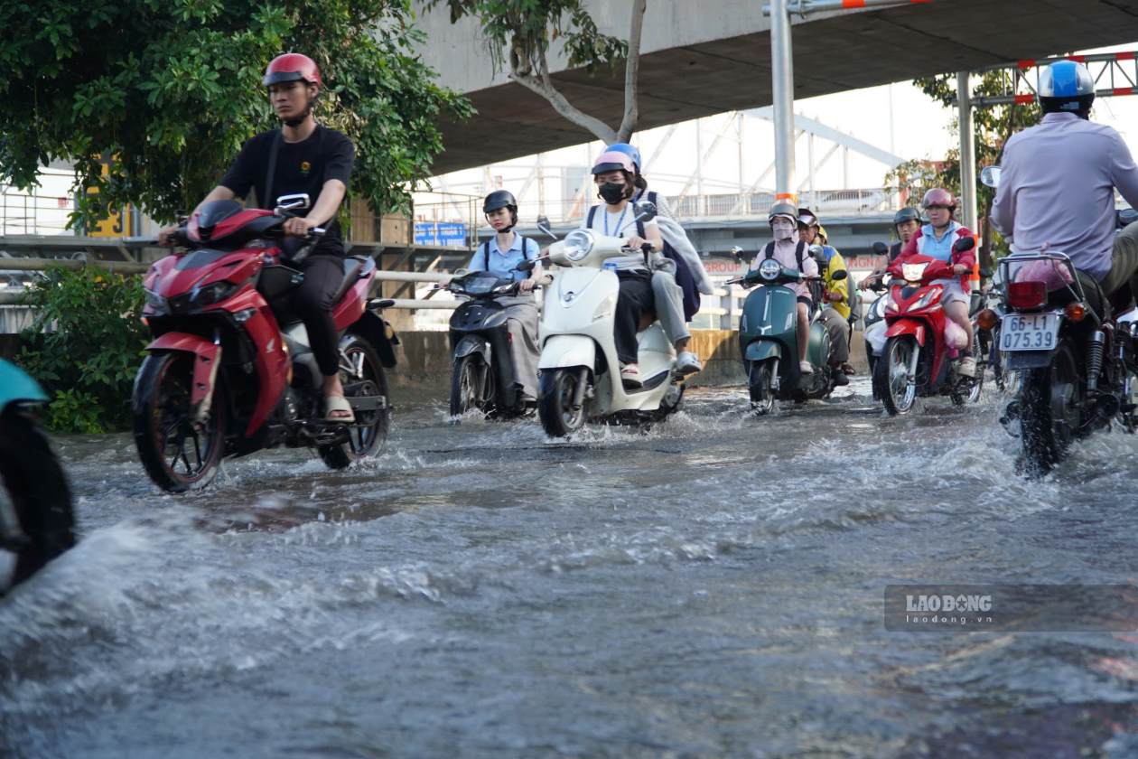 Người dân lội nước trên đường Trần Xuân Soạn sáng 13.10 do triều cường dâng cao. Ảnh: Thái Bảo